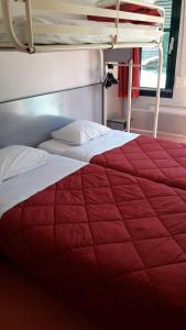 里摩日北里摩日普瑞米尔经典酒店的配有双层床的客房内的一张红白色的床