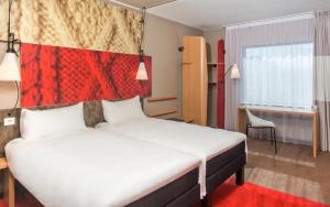 伦敦宜必思伦敦格林威治酒店的一间卧室配有一张大床和红色床头板