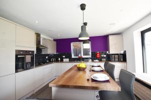 莱斯特Gorse House的厨房配有木桌和紫色墙壁