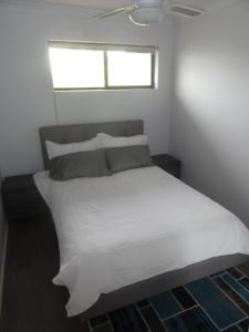 阿德莱德优越位置宽敞度假屋的卧室配有白色的床和窗户