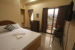 杜马格特心之酒店的一间卧室设有一张床和一个美景窗户。