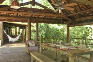 坎布里Casa Sertão de Camburi的木制甲板配有桌子和吊扇