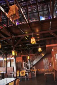 瓜拉丁加奴天使酒店的餐厅设有木制天花板、桌子和吊灯。