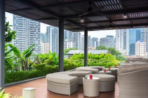 新加坡ST Residences Novena的一个带桌椅的屋顶露台,享有城市天际线
