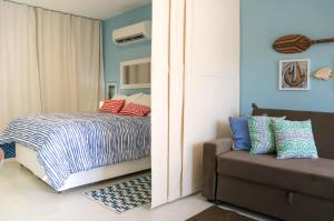皮帕Apartamento Solar Água 107的一间卧室配有一张床和一张沙发