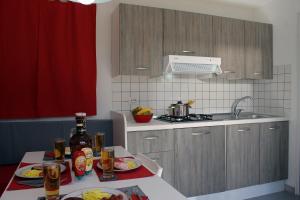 阿尔贝罗贝洛博斯科塞尔瓦维拉焦露营地酒店的厨房配有带食品和饮料的桌子