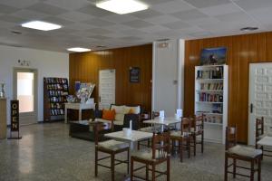ViladamatHostal l'Esplai的图书馆内带桌椅的餐厅