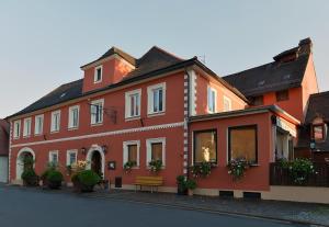 Pommersfelden格鲁纳鲍姆酒店的前面有长凳的红色建筑