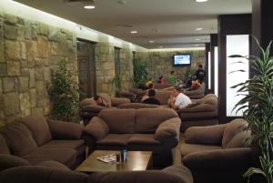 班斯科Gardenia Park Hotel的一群人坐在一个带沙发的等候室里