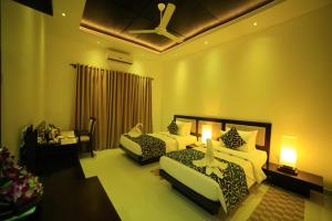 波隆纳鲁沃查雅遗址酒店的酒店客房配有两张床和吊扇。