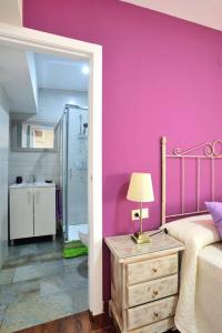 科尔多瓦De Patios的粉红色的卧室设有一张床和一间浴室。