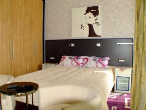 布德瓦子午线酒店的卧室配有一张白色的床、椅子和一张桌子