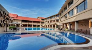 巴夫那加尔Iscon The Fern Resort & Spa, Bhavnagar的大楼前的大型游泳池