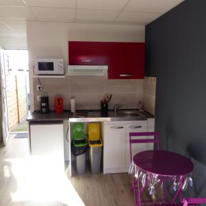锡拉奥Le Bas de Cilaos的一间设有红色橱柜和紫色凳子的小厨房