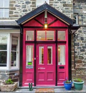 贝图瑟科伊德Summerhill Guest House的砖砌建筑的红色门,有窗户