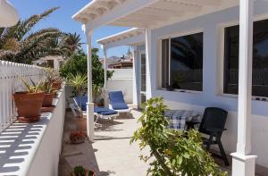 宏达海滩Villa Mela的一个带蓝色椅子和围栏的庭院