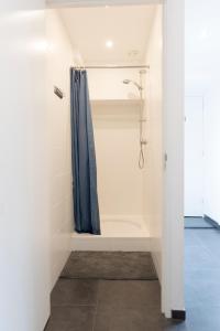 奈梅亨巴巴罗萨旅馆 的一间带蓝色淋浴帘的淋浴的浴室