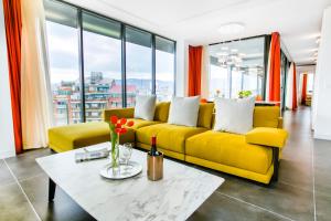 巴塞罗那桑特斯科斯莫公寓的客厅设有黄色沙发,配有窗户