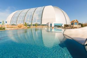 克劳斯尼克热带岛屿度假酒店的一座游泳池,其背后是一座大型建筑