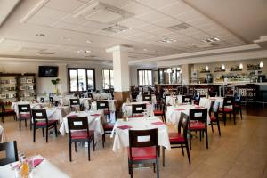 特拉武科新镇艾尔卡普丽池酒店的用餐室配有白色的桌子和红色的椅子