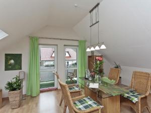 SandebeckApartment in Nieheim on the edge of the forest的一间设有绿色窗帘和桌椅的用餐室