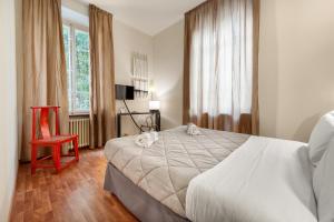 卢卡卢克里西亚卢卡别墅旅馆的一间卧室配有一张大床和一张红色椅子