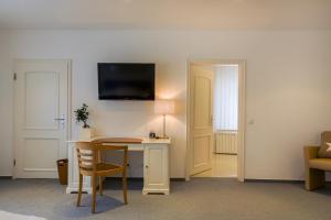 勒讷施瓦酒店的客房设有书桌和墙上的电视。