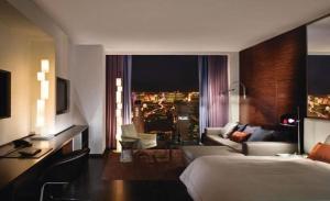 拉斯维加斯帕尔姆斯普雷斯一室公寓带阳台＆斯特里普景公寓式酒店的酒店客房设有床和客厅。