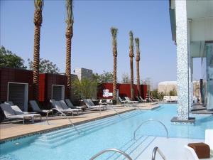 拉斯维加斯帕尔姆斯普雷斯一室公寓带阳台＆斯特里普景公寓式酒店的一个带躺椅的游泳池,棕榈树