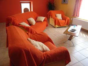 韦姆Quaint Apartment in Ondenval with Terrace的客厅配有2张橙色沙发和1张桌子