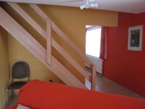 韦姆Quaint Apartment in Ondenval with Terrace的一间卧室设有楼梯和红色的墙壁