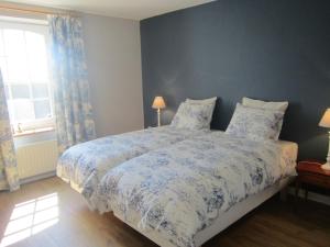 奧法格內Welcoming Cottage in Offagne with Garden的一间卧室配有一张带蓝色和白色棉被的床