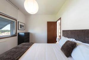 波尔图LovelyStay - Casas Brancas - Modern Apartment with Balcony & free private parking的卧室配有一张大白色床和窗户