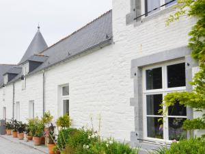 SenzeilleModern Holiday Home in Senzeille with Garden的白色砖屋,有窗户和植物