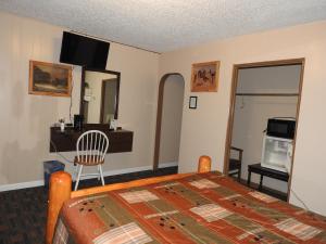 瑟莫波利斯Rainbow Motel的一间卧室配有一张床、一张桌子和一张书桌