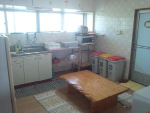 石垣岛碧海白保之宿旅馆的厨房配有水槽和桌子