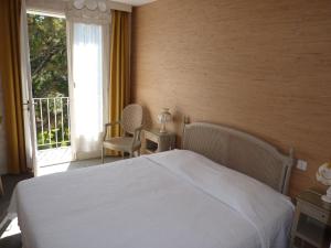 拉波勒协和酒店的卧室配有白色的床和窗户。
