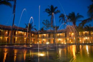 奔巴岛Avani Pemba Beach Hotel的一座建筑,在晚上前方有一个喷泉