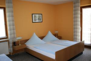 卑尔根贝格内霍夫酒店的一间卧室配有带白色床单和枕头的床。