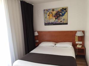 斯特拉斯堡21世纪酒店的卧室配有一张床,墙上挂着一幅画