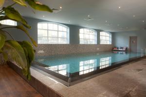巴勒哈姆斯泰德特顿格兰德酒店的一座大型游泳池,位于一座带窗户的建筑内
