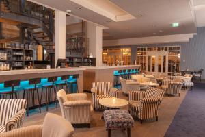 巴勒哈姆斯泰德特顿格兰德酒店的一间带桌椅的餐厅和一间酒吧