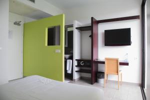 利伯维尔ONOMO Hotel Libreville的客房设有一张床、一张书桌和电视