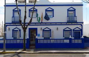 奇皮奥纳Hostal El Puerto Boutique的蓝白色的建筑,前面有树