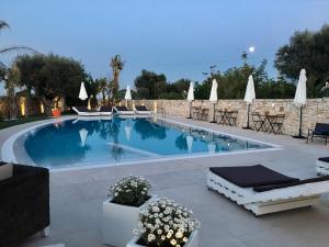 滨海波利尼亚诺Carone Suite-Charme&Pool by Bluette的一个带椅子和遮阳伞的游泳池