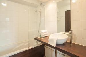 谢勒谢勒城市公寓酒店的浴室配有盥洗盆和浴缸。
