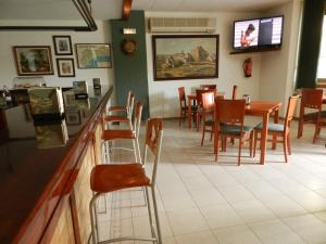 卡拉费尔Hotel El Castell的餐厅设有酒吧和桌椅