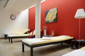 圣英贝特Hotel Restaurant Sengscheider Hof的一间有两长椅的红色墙的房间