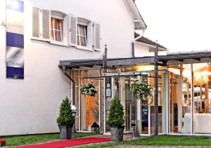 圣英贝特Hotel Restaurant Sengscheider Hof的前面有盆栽树木的白色建筑
