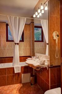 斯兰默多瓦Hotel Nemira的一间带水槽、浴缸和镜子的浴室